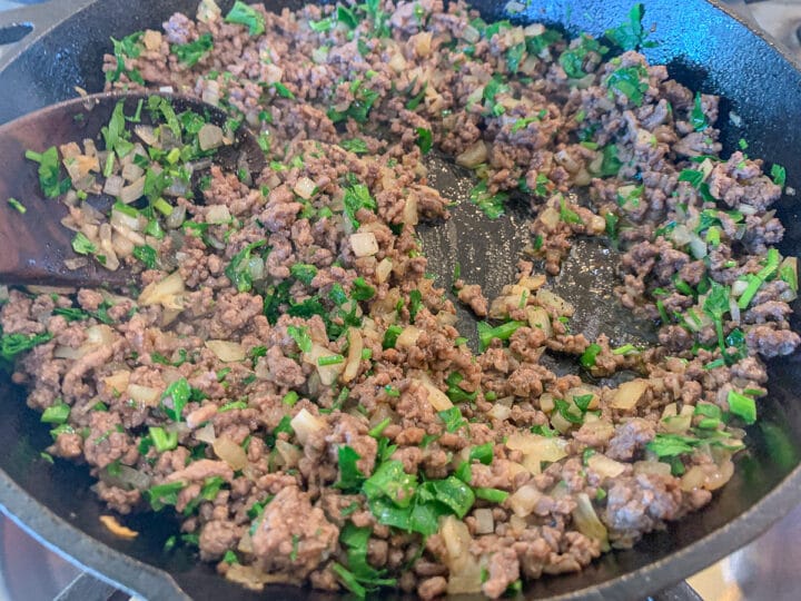 meat, onions, and parsley in a pan