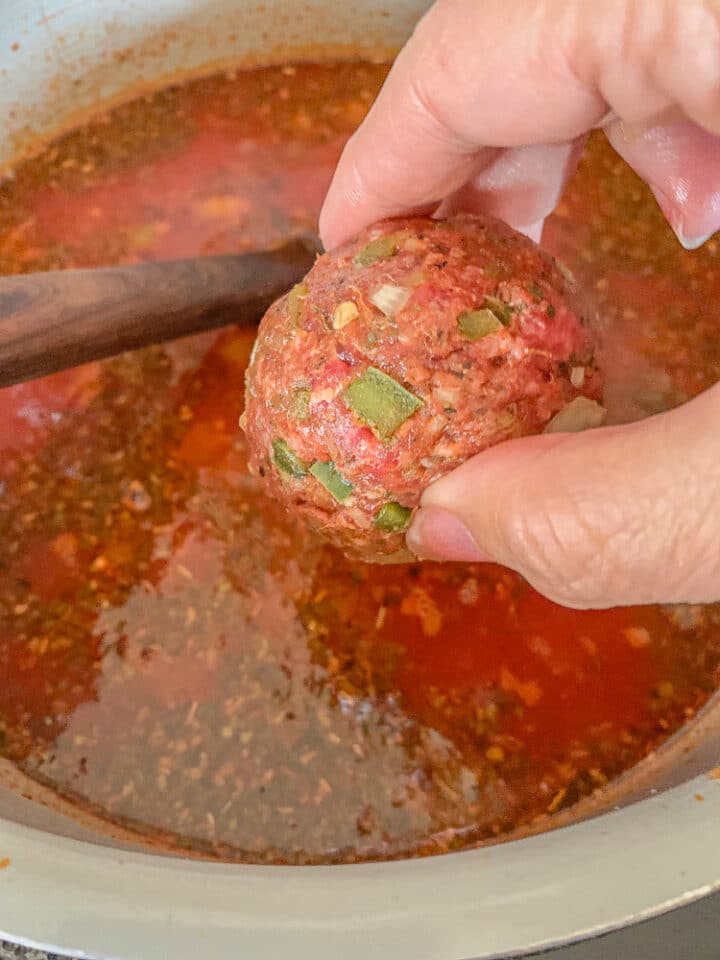 adding meatballs to soup