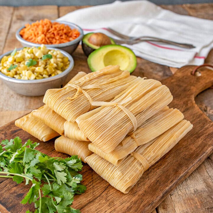 tamales on a cutting board with fixings