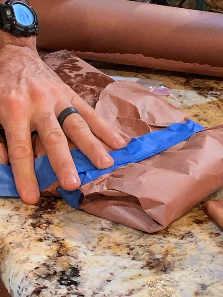 smoked brisket being wrapped in butcher paper