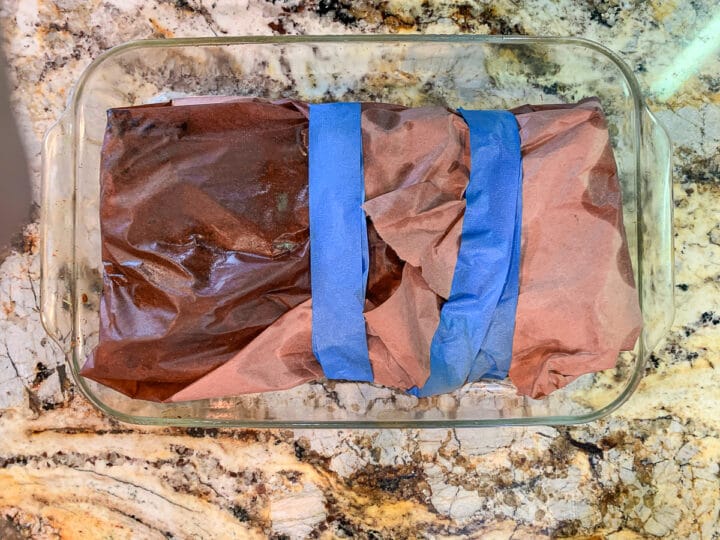 butcher paper wrapped beef in a glass dish