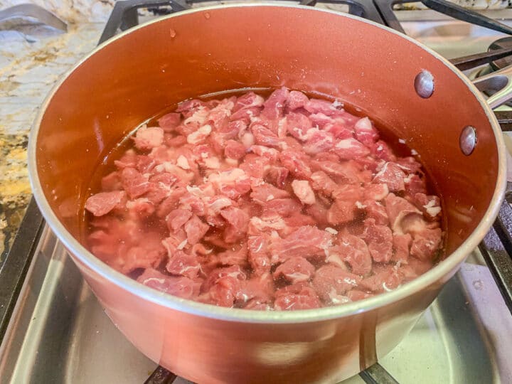 diced meat in a pot, covered with water