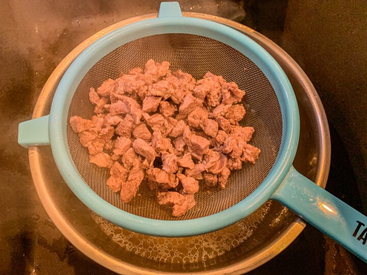 diced meat in a strainer