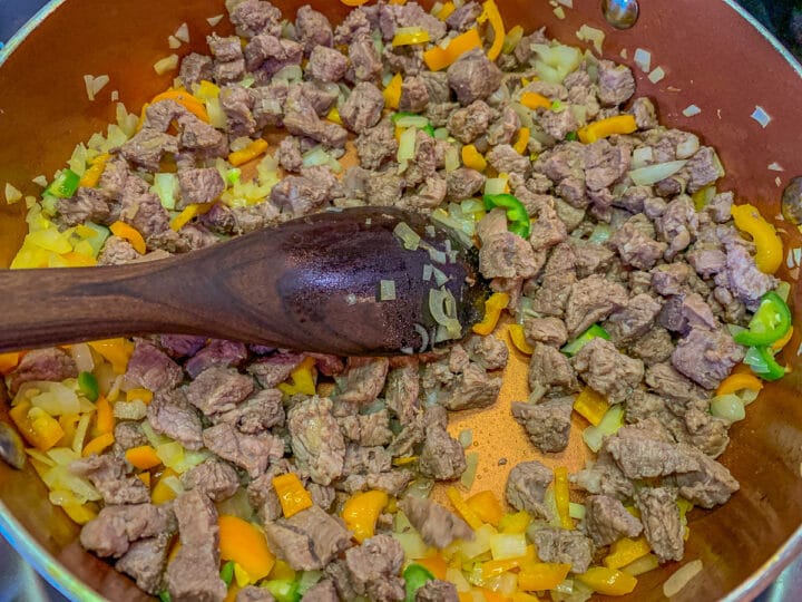 diced meat, peppers and onions in a pan
