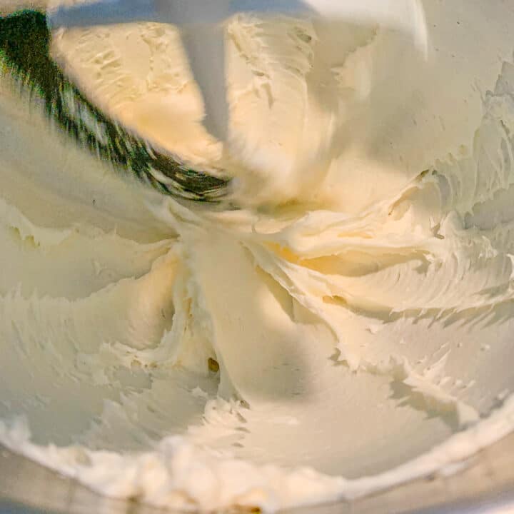 cream cheese being mixed in a stand mixer