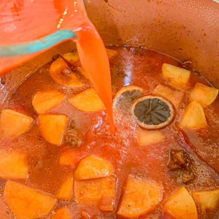 pouring tomato sauce over Shalgam stew