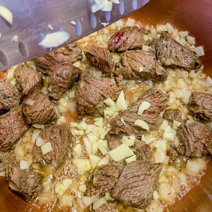 cubed meat and onions in a pot