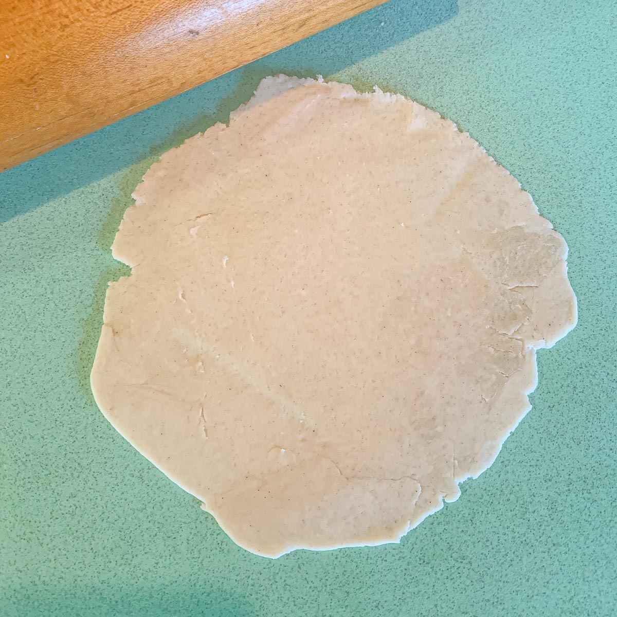 rolling dough on a blue cutting board