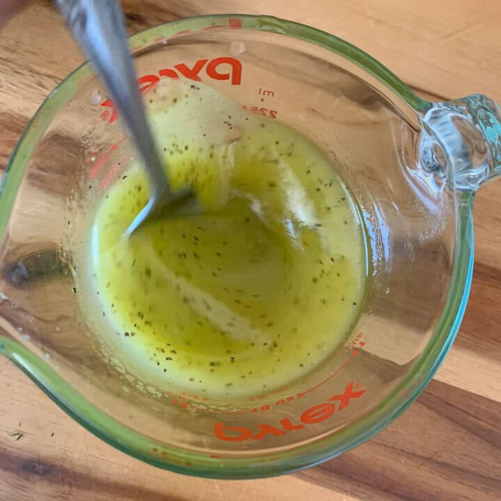 dolmades dressing in a measuring cup
