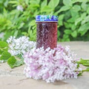 lilac syrup in a bottle surrounded by lilacs