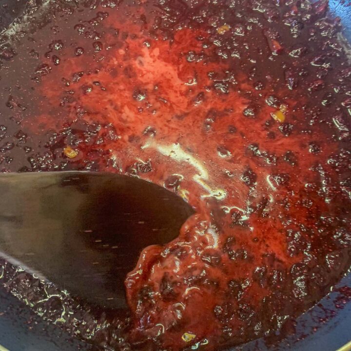 stirring huckleberry chutney in a pan