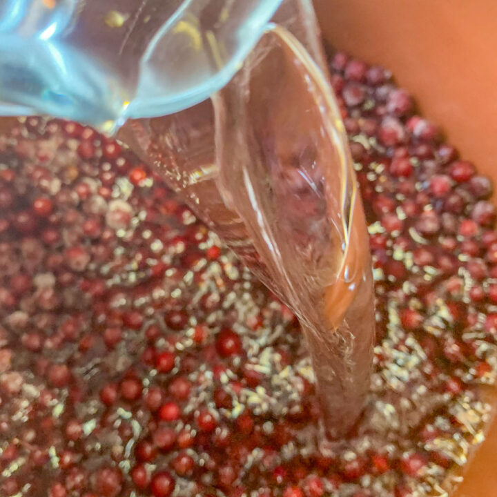 pouring water over a pot of chokecherries