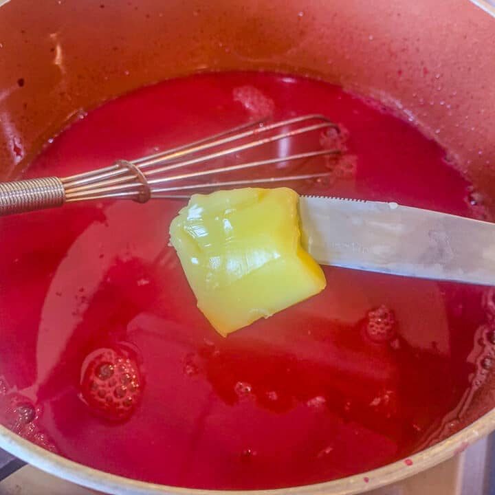 adding butter to chokecherry jelly