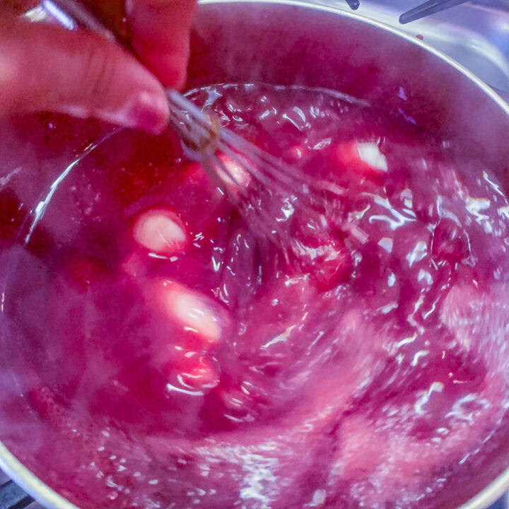 stirring sugar into chokecherry jelly