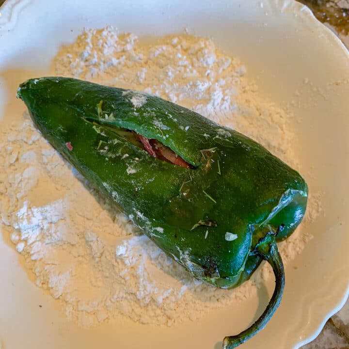 stuffed poblano pepper for Chile Relleno being coated in flour
