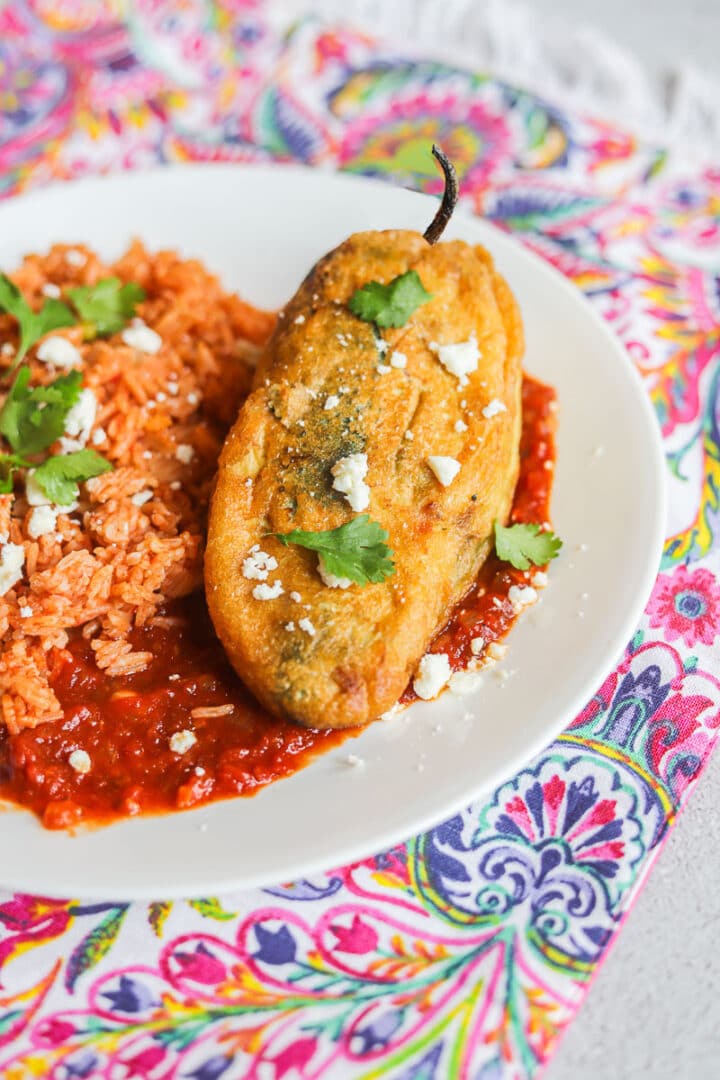 Chile Relleno and rice on a white plate