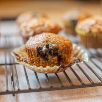 Zucchini Blueberry Muffins on a paper muffin cup