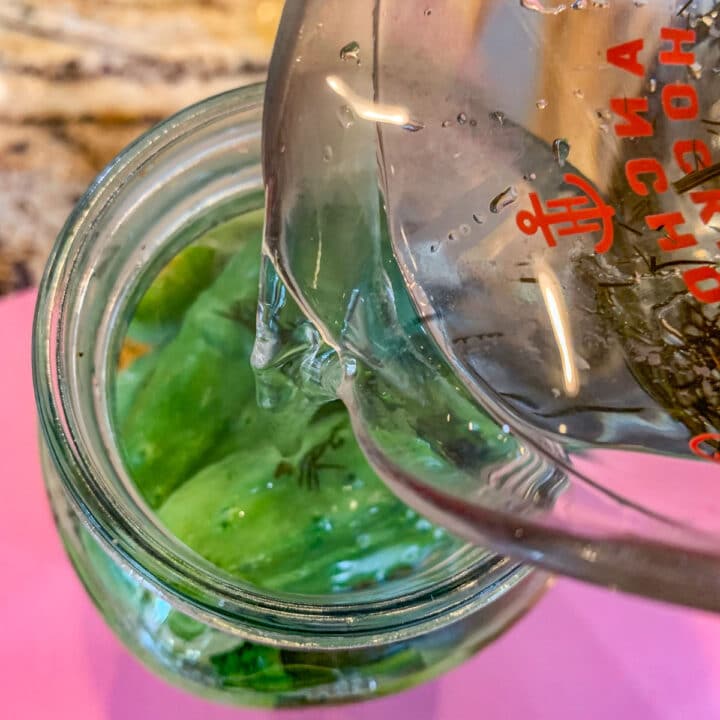 pouring brine over refrigerated dill pickles