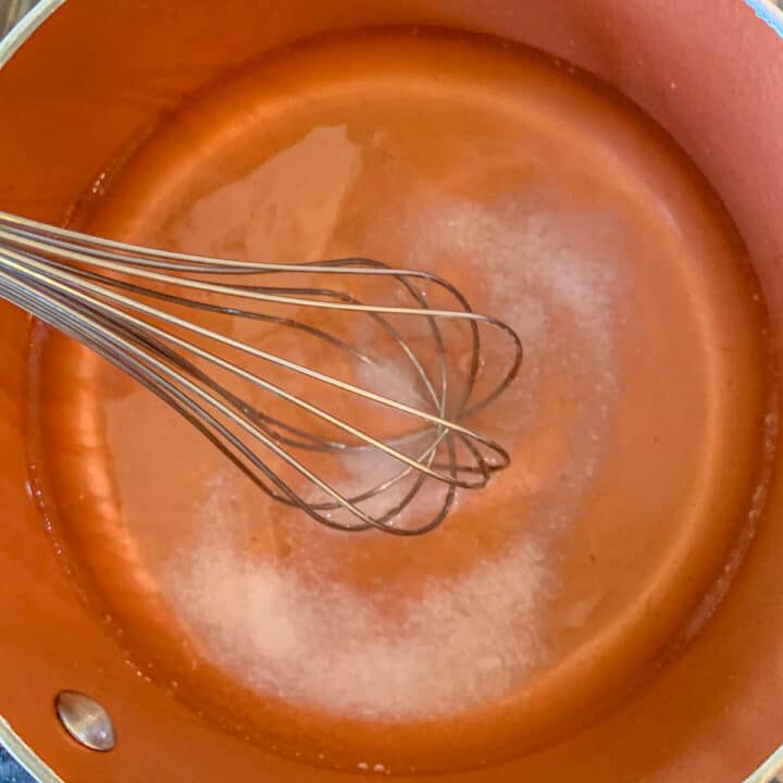water and salt being whisked in a pot