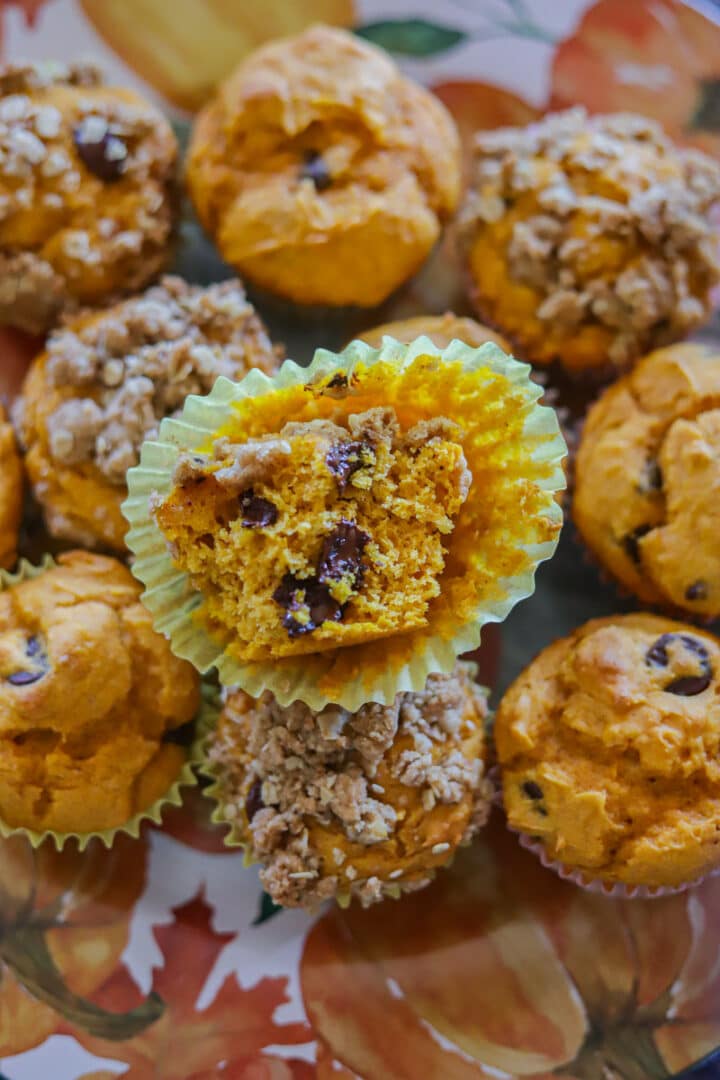 a plate of cake mix pumpkin muffins with a half eaten one on top
