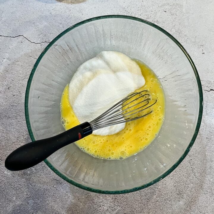 ingredients being whisked in a glass bowl