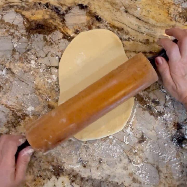 rolling dough on a marble counter