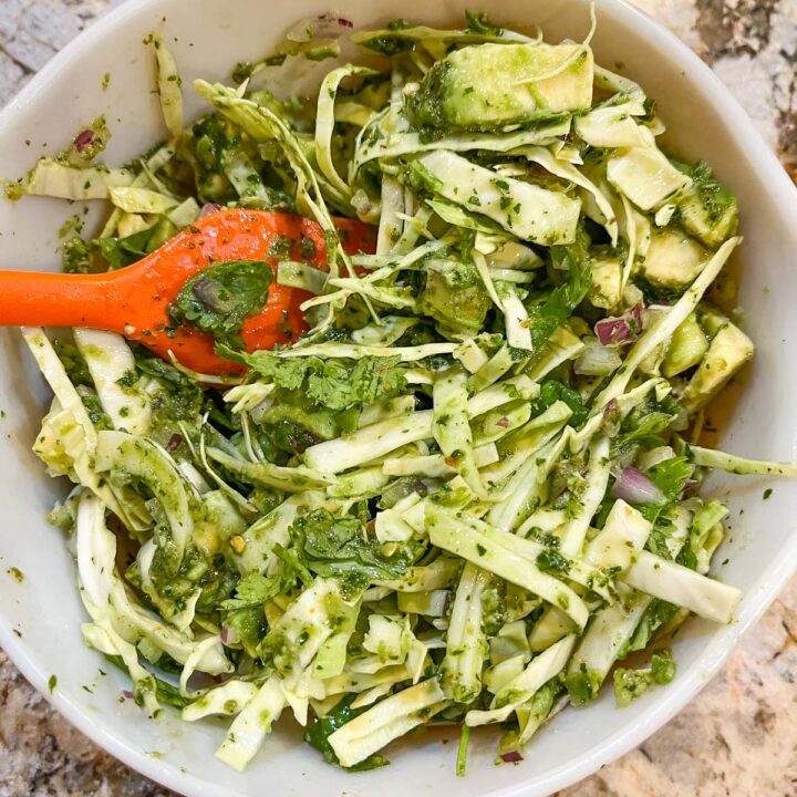 mixing cabbage slaw in a bowl