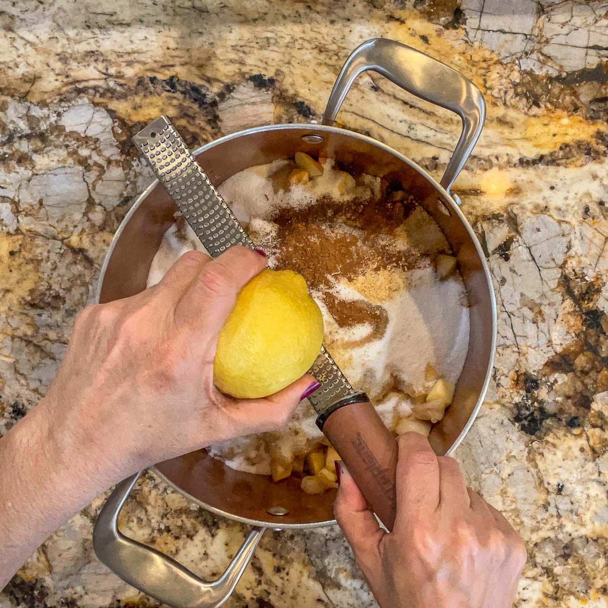 zesting a lemon into a pot for jam
