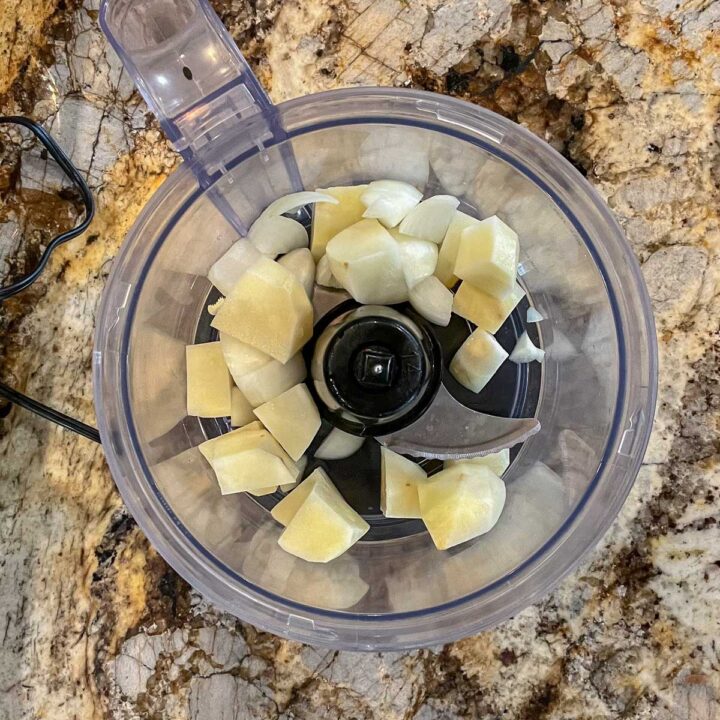 Chopped onions and potatoes in a food processor