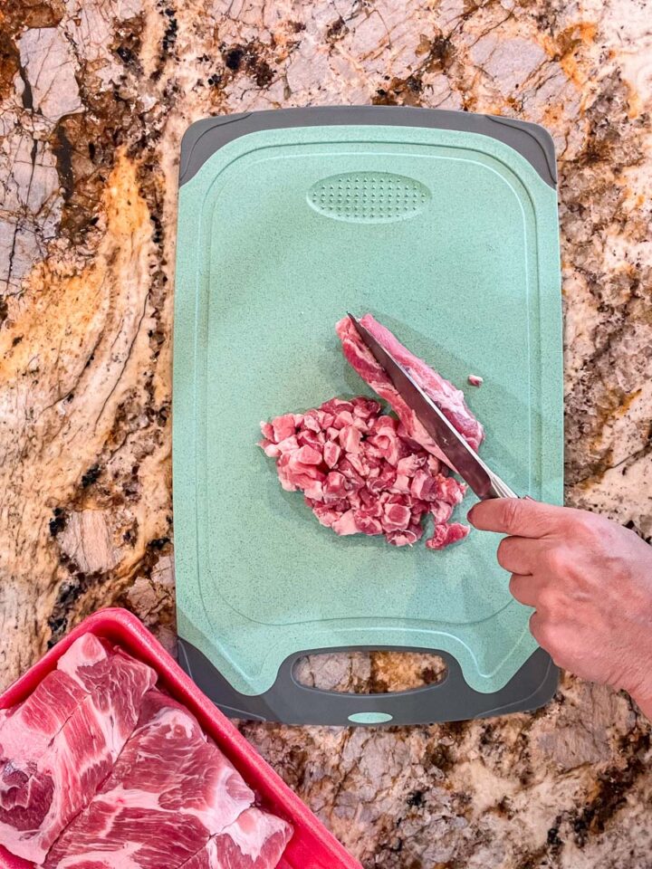 slicing meat on a blue cutting board
