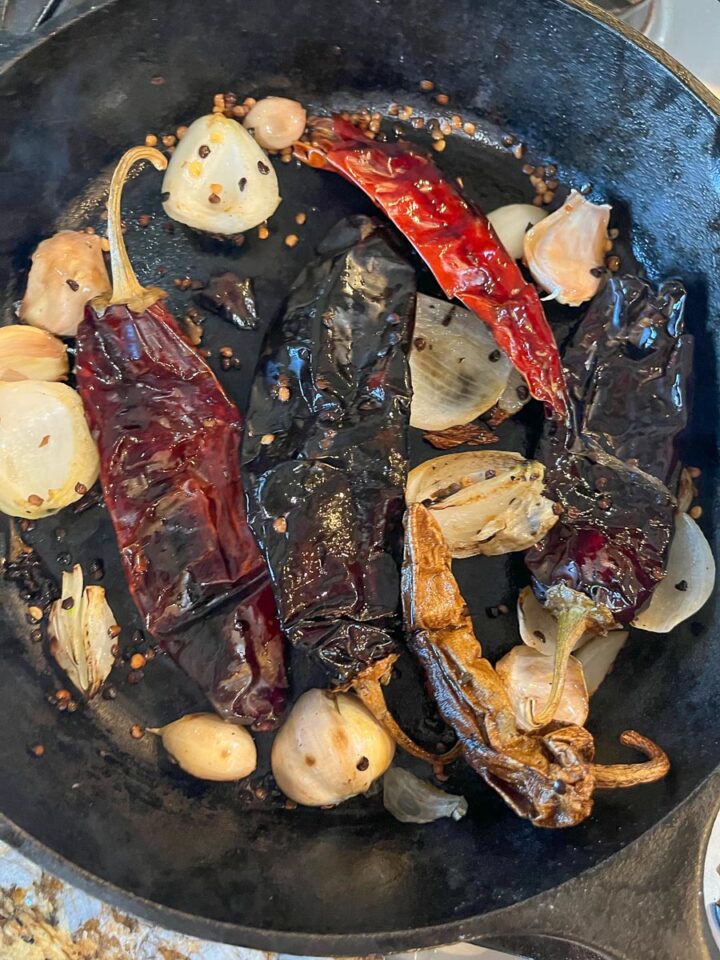 toasted chiles, garlic, and onions in a cast iron skillet