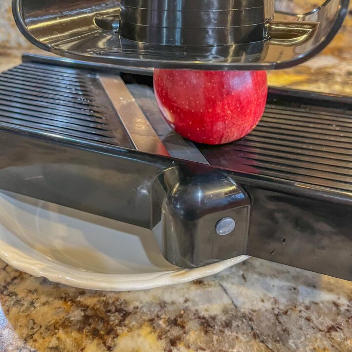 apple getting ready to be sliced with mandolin