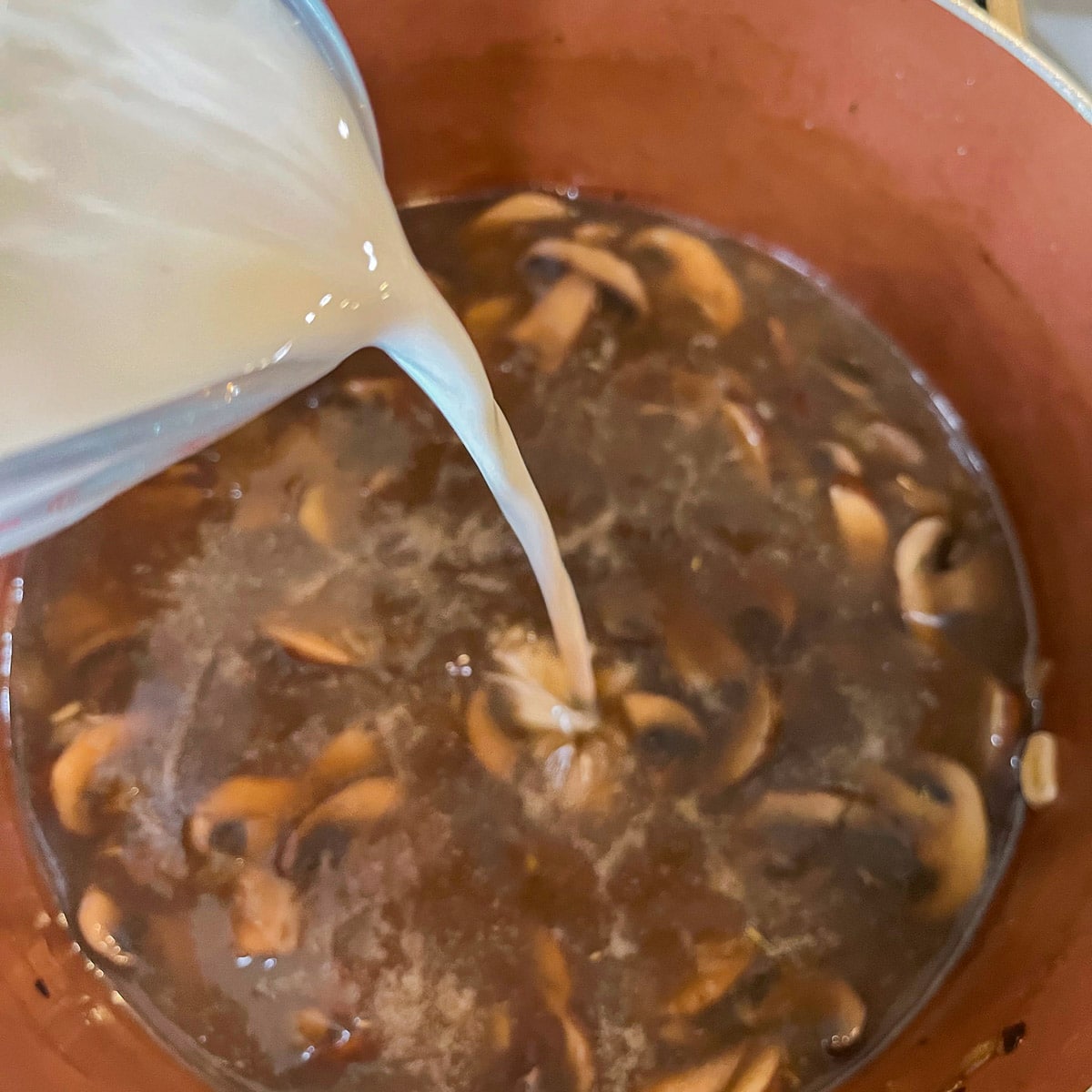 pouring cream into mushroom soup