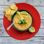 cream cheese chicken chili on a red mat with tortilla chips