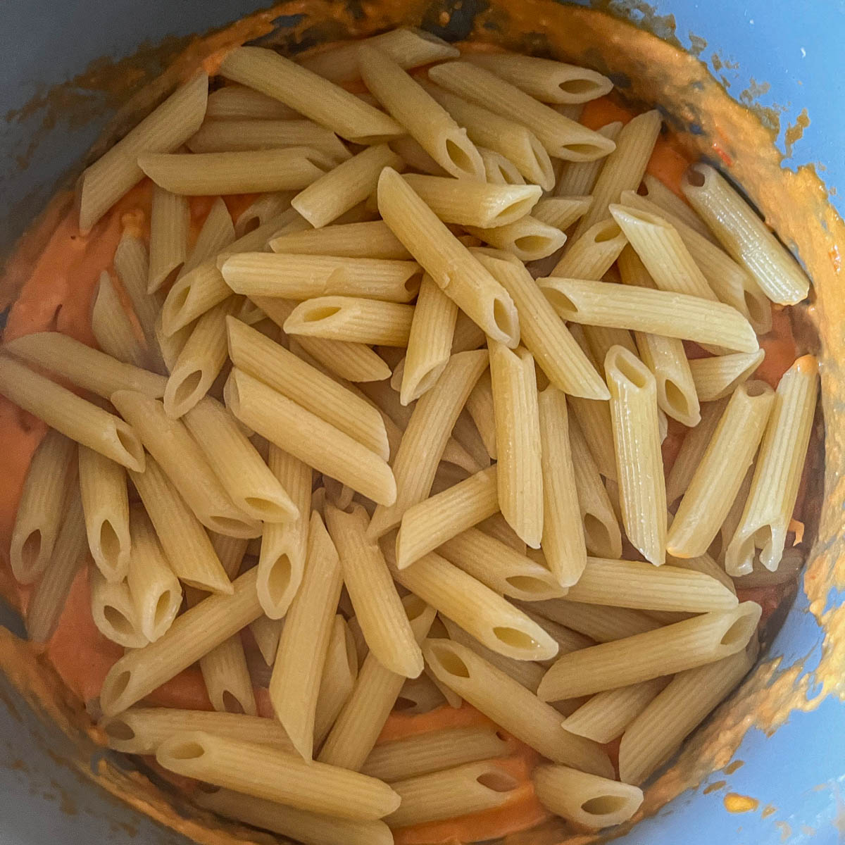 pasta over sauce in a pan
