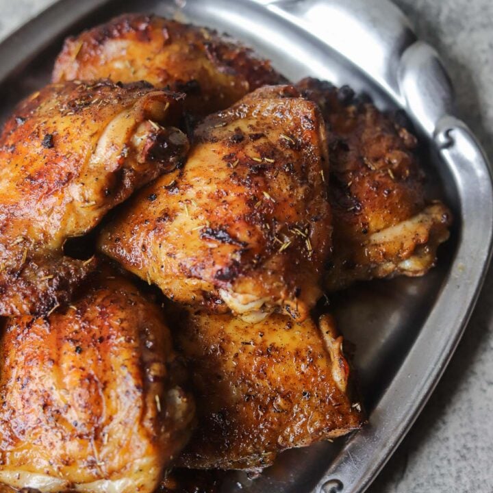 smoked chicken thighs on a silver tray