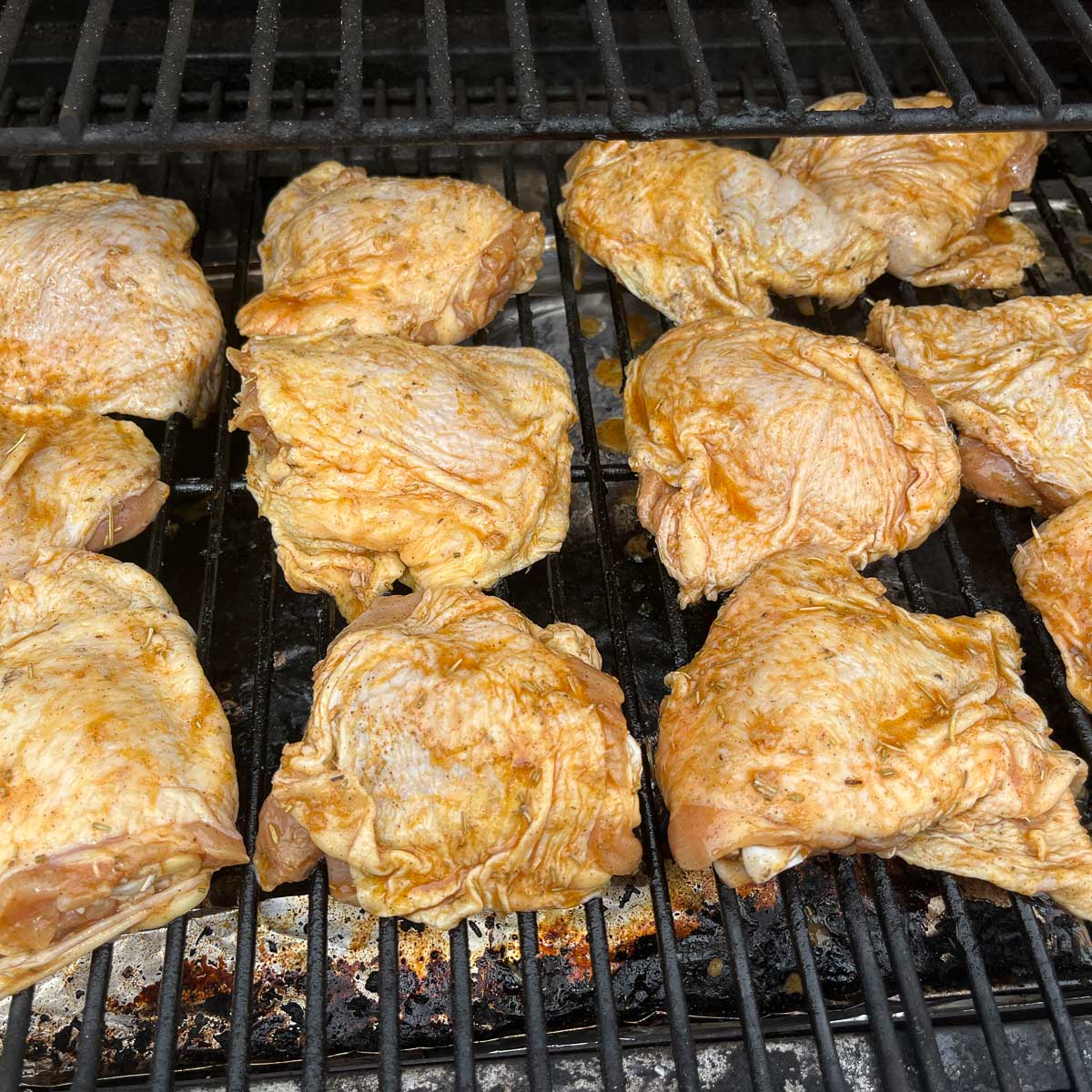 raw marinated chicken thighs being smoked