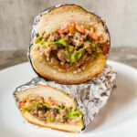 chopped cheese sandwich sliced in two