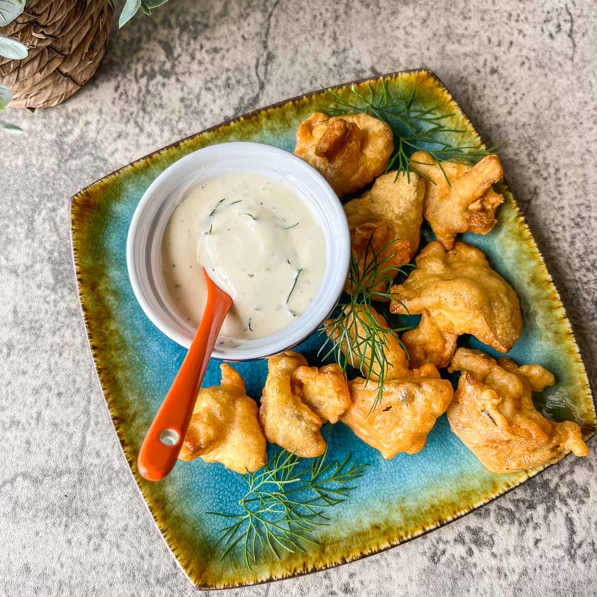 fried chicken mushrooms on a blue plate with ranch dressing