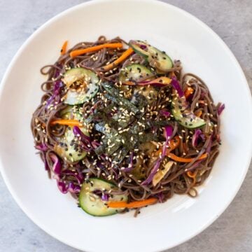 gluten free soba noodles topped with nori and sesame seeds on a white plate