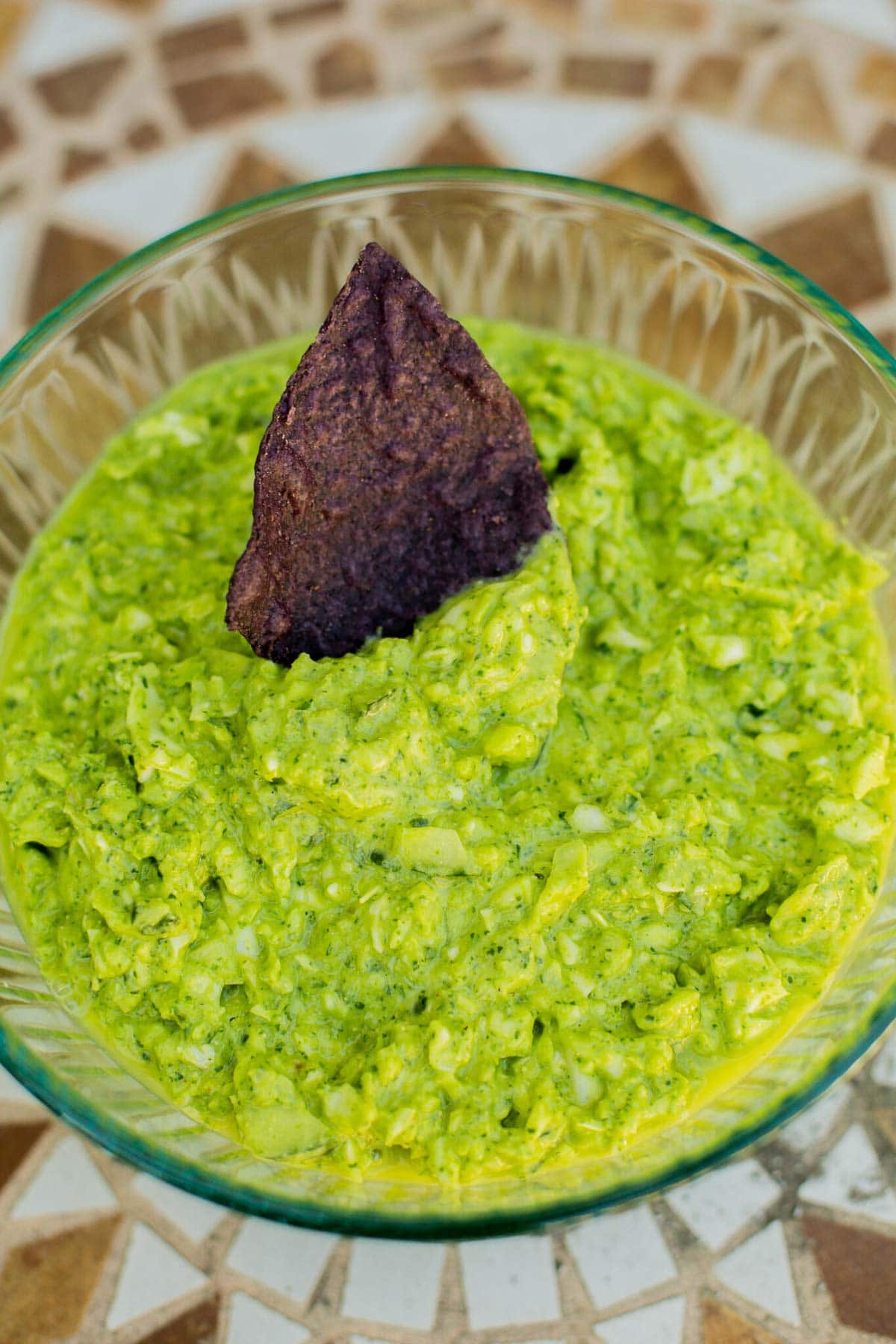 Green Goddess dip in bowl with blue corn tortilla chip