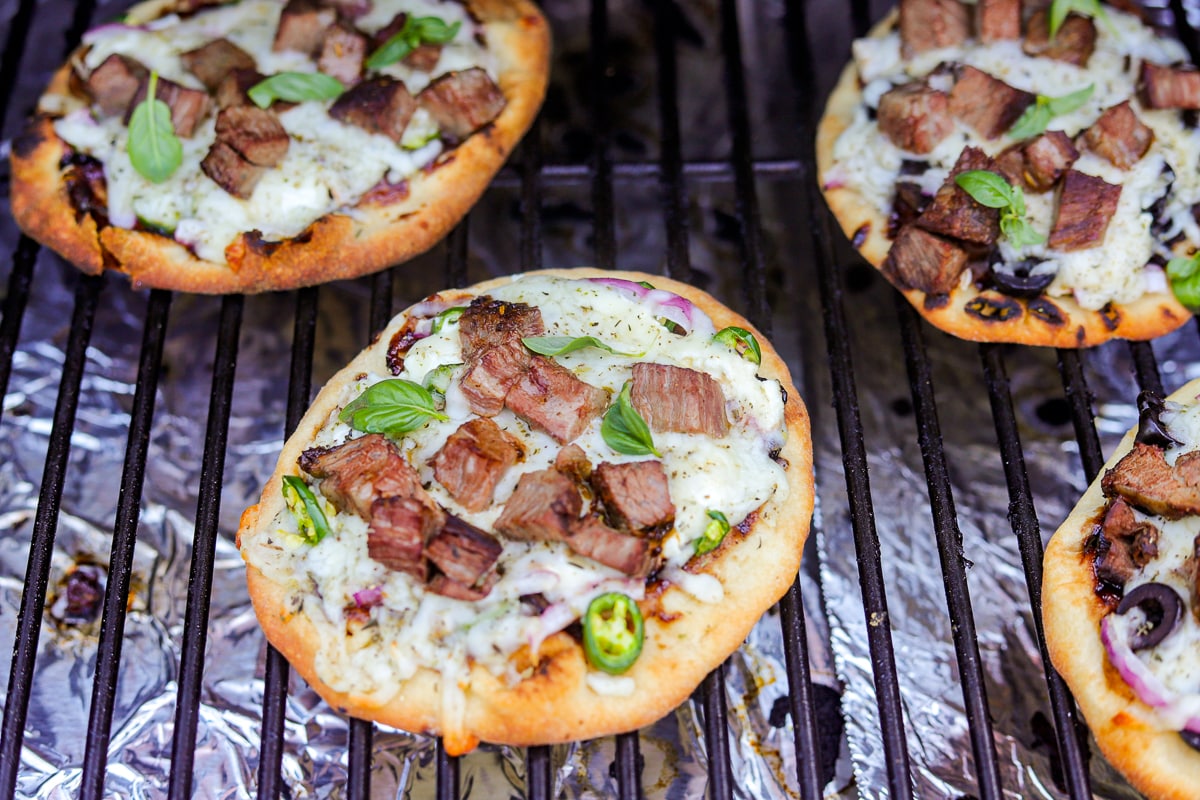 four smoked pizzas on the grill