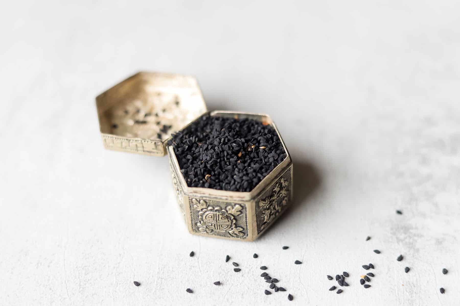 silver snuff box filled with nigella seeds