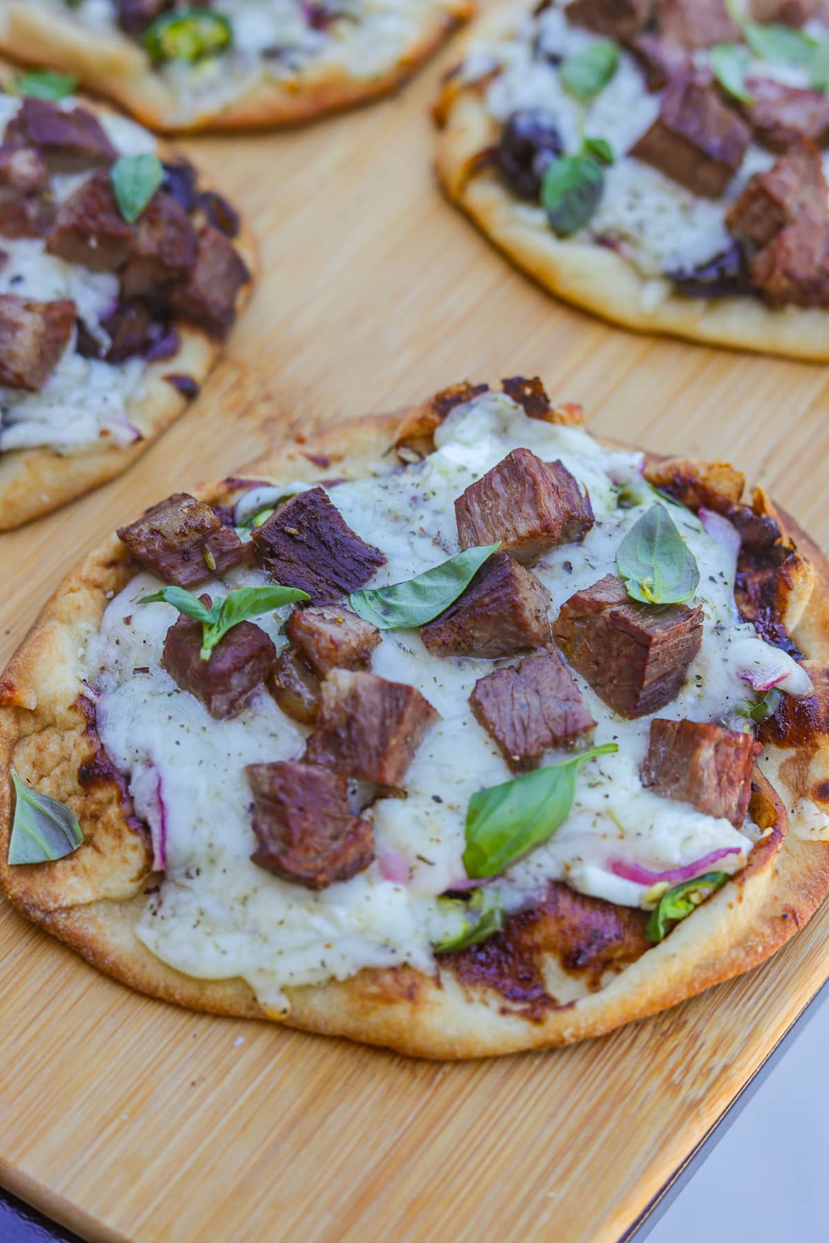 naan bread pizzas on a cutting board