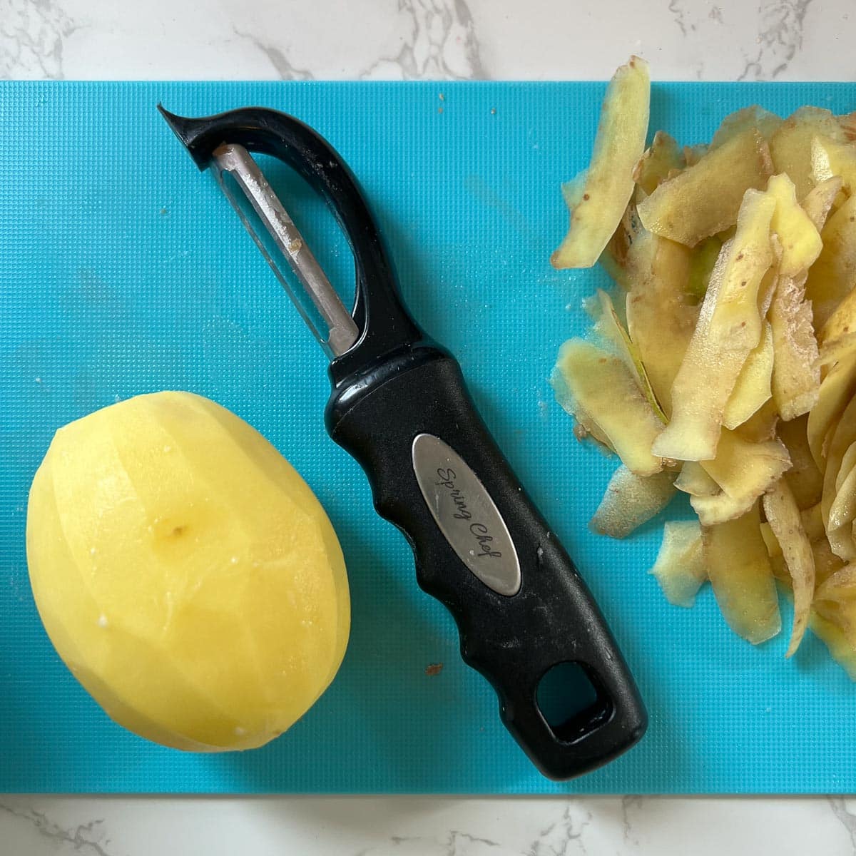 peeled potato on a cutting board