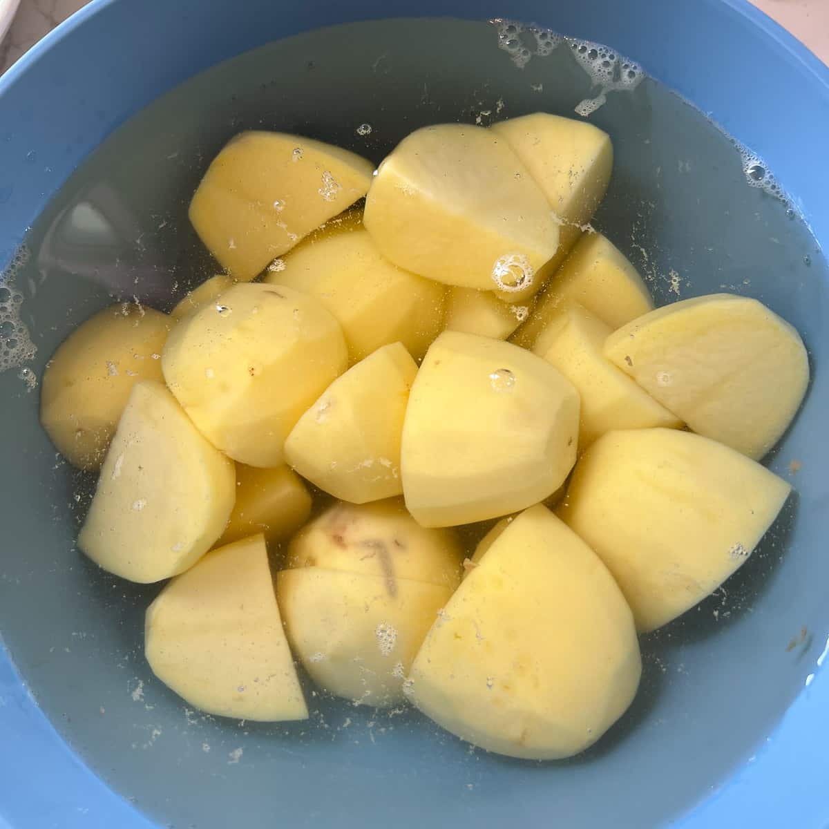 peeled and chopped potatoes soaking in cold water