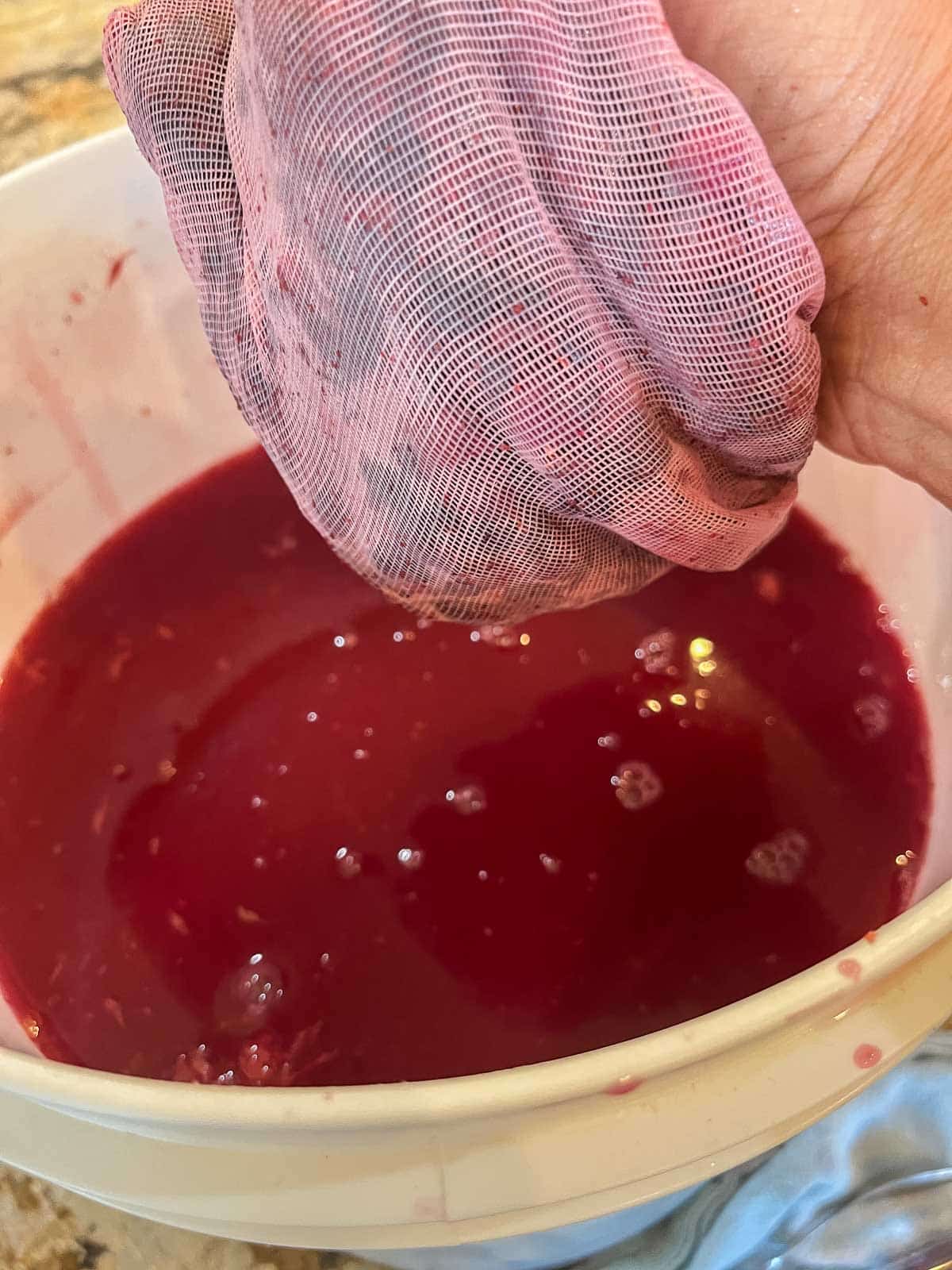 squeezing berries into fermentor bucket