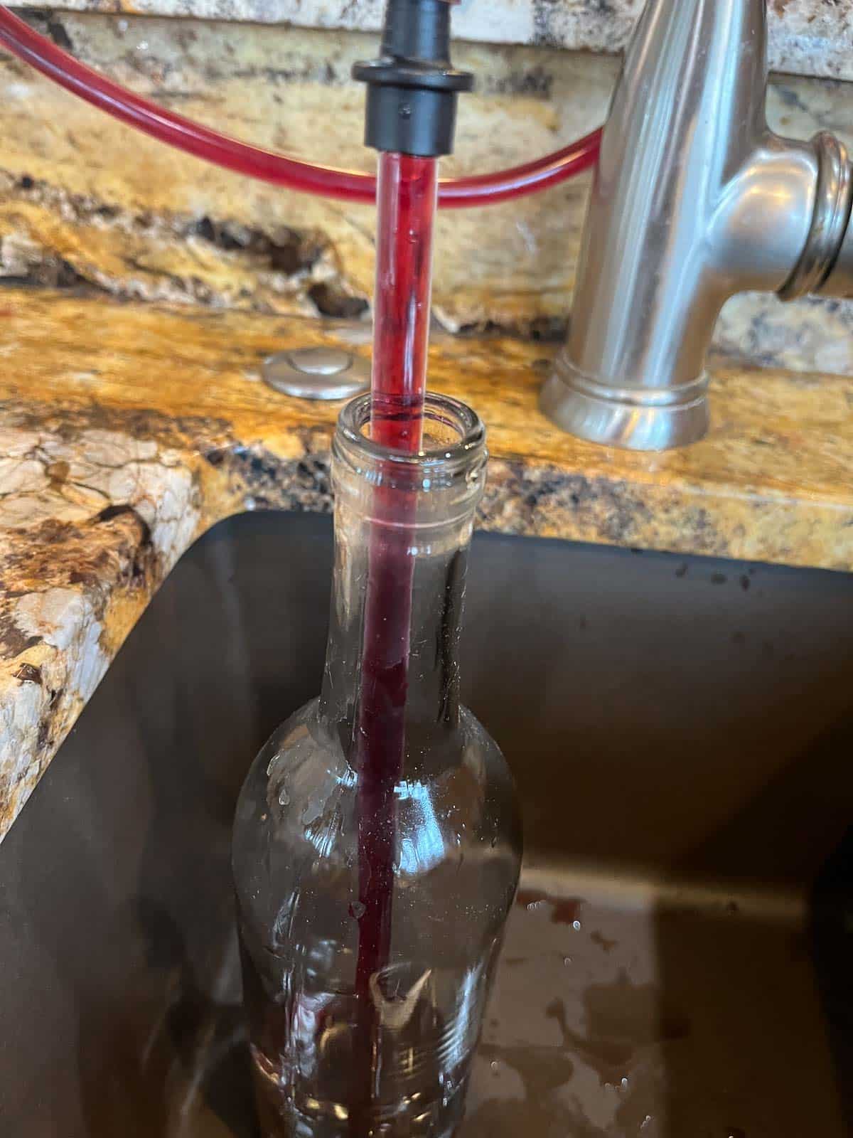 filling wine bottles with blueberry wine
