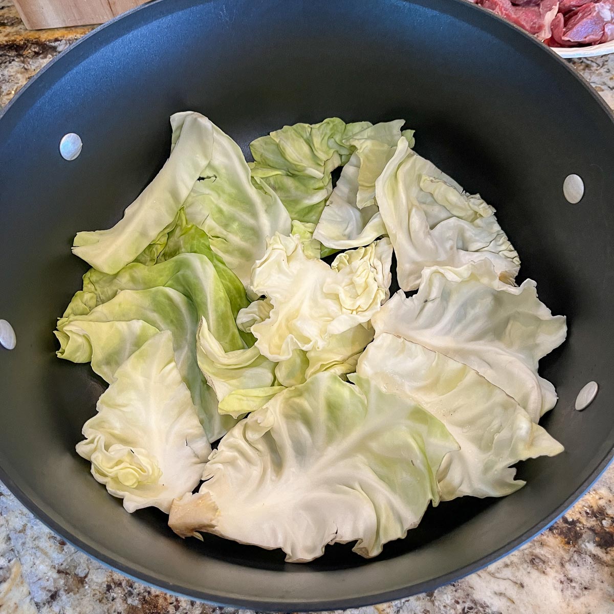 a pot with cabbage along the bottom