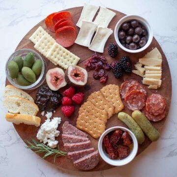a round charcuterie board topped with cheese and various items
